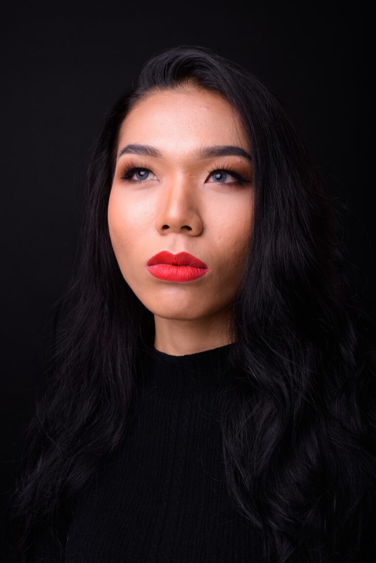 Young beautiful Asian transgender businesswoman against black background